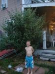 my son standing in front of my butterfly bush before bloom time.