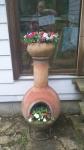 Chiminea with clay pot on top and Impatiens